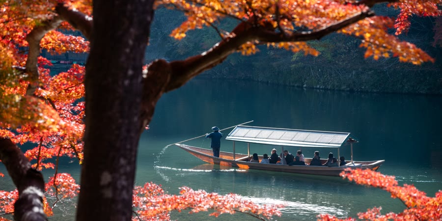 川に浮かぶ舟と紅葉の風景